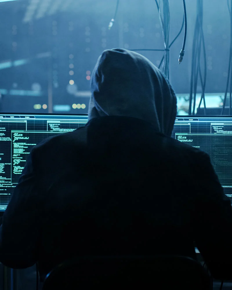 Hacker vorm Code symbolisch für die Cybergefahren